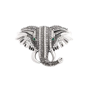 Vintage elephant head brooch with sparkling rhinestones and green eyes on white background