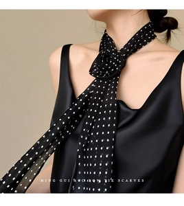 Détail d'un foulard en soie à pois noirs vintage avec un nœud de rose 3D élégant