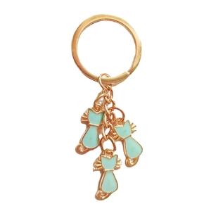 Chic gold-plated keychain with three mint green enamel cat pendants on a white background