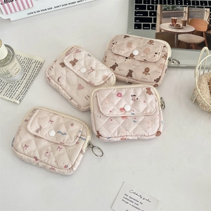 Detailed view of quilted cotton card holders with cartoon floral patterns and zip closure