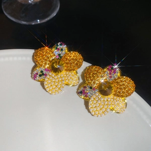 Macro shot of floral earrings with multi-colored crystals and pearls on white porcelain