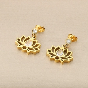 Détail de boucles d'oreilles lotus dorées avec zircons étincelants et pétales évidés