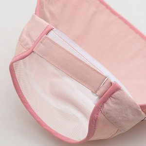 Detail view of pink sun visor with adjustable velcro strap and breathable mesh lining