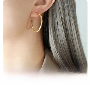Close-up of model wearing 18k gold plated titanium steel C-shape earrings for women