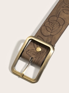 Macro view of vintage brown leather belt featuring intricate embossed rose floral patterns