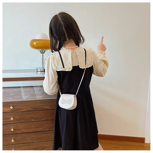 Rear view detail of girls' black and white layered dress with Peter Pan collar and bow bag