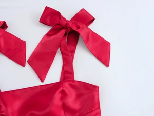 Gros plan détaillé d'une robe en satin rouge avec un grand nœud décoratif sur l'épaule