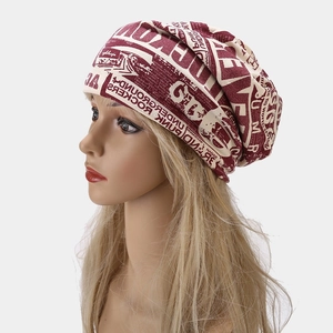 Macro detail of beige slouchy beanie featuring burgundy punk rockers letter print