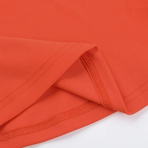 Detail of double-needle hem stitching and fine knit texture on orange mini dress