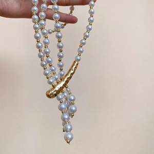 Detail of multi-layered pearl necklace with vintage irregular gold metal fastener