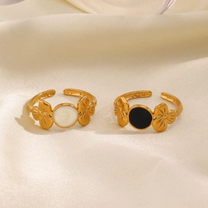 Adjustable golden flower ring with black and white enamel finish on silk background