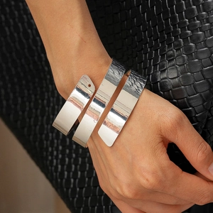 Detailed view of silver layered spiral cuff with polished and hammered metal textures