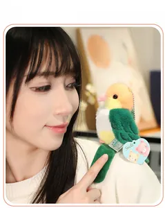Detail of cute parrot plush keychain with heart tag and metal chain on a white backpack