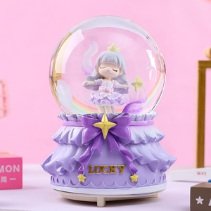 Close-up of a rotating musical crystal ball with a girl figurine and LUCKY gold text
