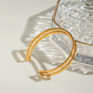 Detail of 18k gold plated stainless steel double line bangle with water ripple shadow