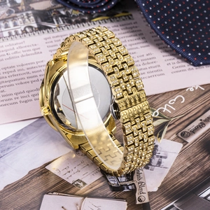Detailed back view of gold iced-out watch with crystal accents and folding clasp
