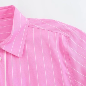 Dettaglio del colletto della camicia a righe rosa e bianche con cuciture e asola