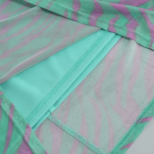 Detail of green and purple abstract print mesh fabric with smooth inner lining
