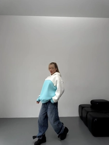 Full-body shot of oversized color-block hoodie with dropped shoulders and wide-leg jeans