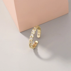 Close-up of golden paperclip ring with zircon pavé and adjustable open band design