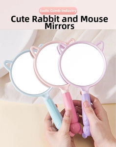 Close-up of cute rabbit-eared handheld makeup mirrors in pastel pink, blue and purple