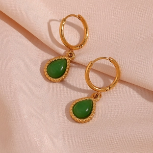 Detailed macro view of golden hoop earrings with teardrop green cat eye stone pendants