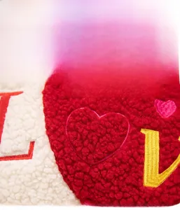 Detail of red and white lamb wool pillow featuring high-quality heart letter embroidery