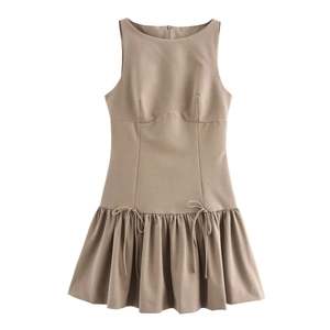 Detailed view of the tan sleeveless mini dress with bow accents and pleated hem details