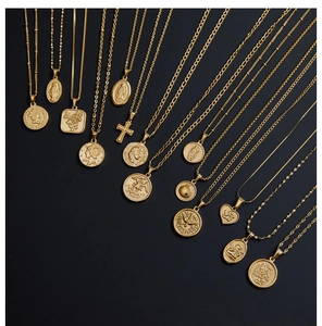 Close-up of vintage 18K gold plated titanium necklaces with assorted religious pendants