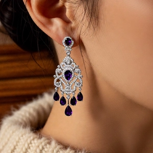 Detail of luxury purple zircon flower tassel earrings worn by a model in soft light