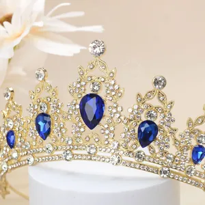 Detailed close-up of golden crown with blue teardrop stones and sparkling crystals