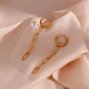 Detail of 18K gold-plated stainless steel paperclip chain earrings on pink silk fabric