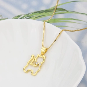 Minimalist 18k gold plated cat necklace with zircon accents on an elegant ceramic plate