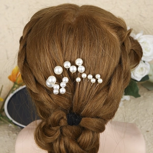 Detailed view of handmade pearl U-shaped hair pins styled in a bridal updo hairstyle