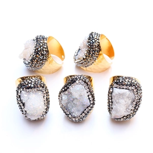 Macro detail of five gold druzy rings with white crystals and double rhinestone borders