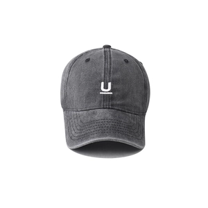 Close-up of the washed cotton fabric texture and white embroidered U logo on the dark grey cap
