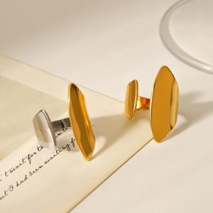 Macro detail of irregular polished gold and silver stainless steel rings on paper