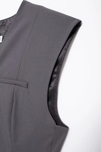 Close-up of grey V-neck vest showing twill fabric texture and fine stitching detail