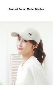 Close-up of beige baseball cap with black DYJ embroidery detail on the side
