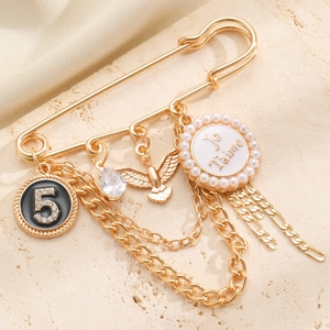 Makro-Detail der goldenen Vintage-Brosche mit Adler-Anhänger und Perlen-Anhänger