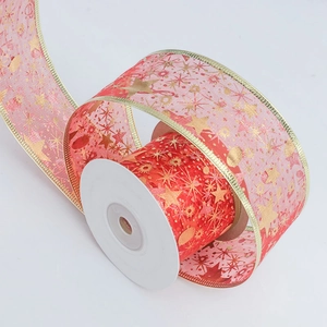 Detail of red sheer organza ribbon with gold foil stars and snowflakes on a roll