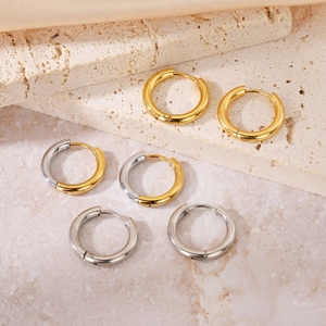 Classic round hoop earrings in gold, silver and two-tone finishes on a stone display