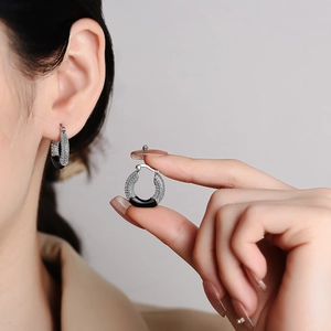 Elegant silver donut earrings with pavé crystals and black enamel on a fashion model