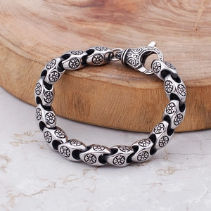Detailed macro view of vintage stainless steel chain bracelet with carved floral patterns