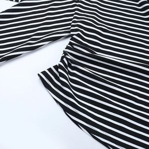 Détail de la texture côtelée à rayures noires et blanches sur ce haut en tricot à manches longues