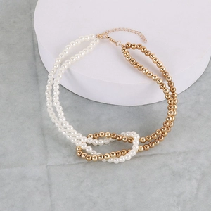 Detailed shot of double-layer necklace with white faux pearls and gold beads on a pedestal