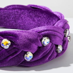 Macro view of purple velvet headband with braided texture and shiny rainbow rhinestones
