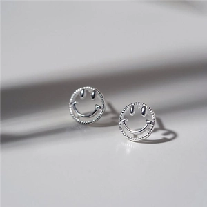 Macro view of sterling silver smiley face earrings with decorative beaded edges