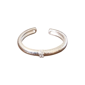 Minimalist silver open ring with brushed texture and a sparkling zircon stone inlay