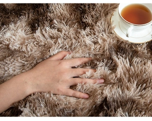 Close-up of soft plush round rug in brown gradient showing long hair texture detail